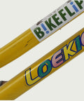 12.76 - BikeFlip, 12 inch kinderfiets, geel en paars, Loekie, terugtraprem, handrem, kabelslot, vrolijk, voor beginners fiets